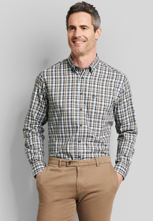 Herren Langarmhemd mit Karomuster in einer Mischung aus Blau, Braun und Schwarz. Verfügt über einen Button-Down-Kragen und eine Brusttasche. Kombiniert mit beigen Hosen.