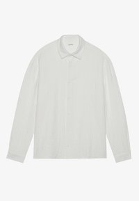 Chemise blanche à manches longues avec un tissu texturé, un col pointu et une fermeture à boutons à l'avant. Elle dispose d'une poche sur le côté gauche.