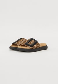 Sandaler med leopardmönster och svart spänne, tanfärgad innersula och texturerad gummisula, med öppen tå och platt design.