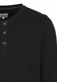 Schwarzes Langarmshirt mit strukturierter Oberfläche, ausgestattet mit einer Knopfleiste mit drei Knöpfen und einem kleinen Logo auf der Brust. Weicher Stoff.