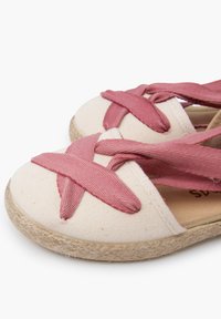 Espadrillas in tela con corpo beige e fasce incrociate rosa, dotate di una suola in juta textured e design a punta rotonda.