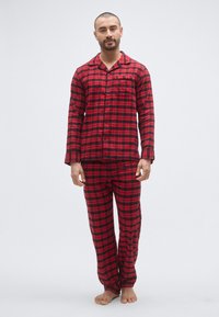 Czerwono-czarny zestaw piżamowy w kratę wykonany z flaneli, składający się z rozpinanej góry i pasujących spodni, o luźnym kroju i z kieszeniami.