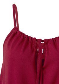 Burgundské bezrukávové tričko s nastavitelnými ramínky, nabíraným výstřihem a otvorem ve tvaru klíče na zadní straně. Vyrobeno z jemné, elastické látky.