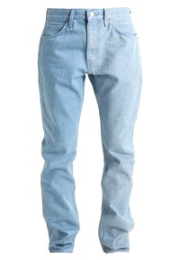 Jeans in denim azzurro chiaro con una texture leggermente consunta, cinque tasche, chiusura con bottone e un pannello scolorito a contrasto su una gamba.