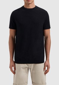 Zwarte korte mouwen crew neck trui, gemaakt van gestructureerde stof, met geribde randen bij de hals en de zoom. Draag over lichte broeken.