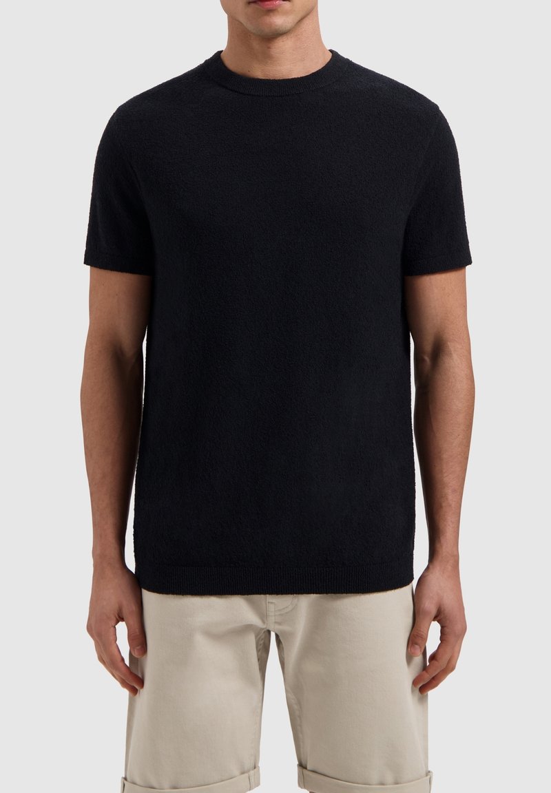 Zwarte korte mouwen crew neck trui, gemaakt van gestructureerde stof, met geribde randen bij de hals en de zoom. Draag over lichte broeken.