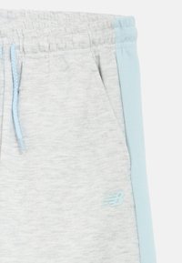 Ανοιχτό γκρι φόρμες με υφή, που διαθέτει μια μπλε ρίγα τονισμού και μπλε κορδόνι. Περιλαμβάνει ένα μικρό λογότυπο σε ανοιχτό μπλε.