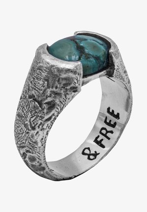 Silberring mit strukturiertem Finish, versehen mit einem ovalen Türkisstein. Innen eingraviert mit "& GRATIS." Auffällige, organische Form und Design.