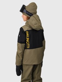 Chaqueta de esquí negra y verde oscuro con capucha, con un logotipo amarillo en la parte posterior. Combinada con guantes negros y un gorro verde oliva.