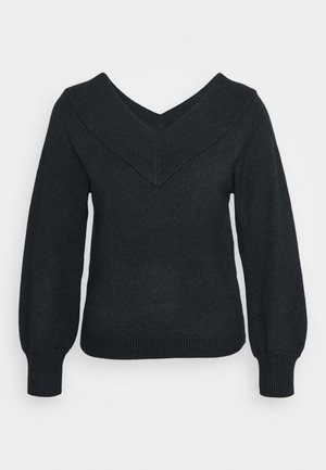 Pull noir avec un col en V profond, des poignets et un ourlet côtelés. Le tissu a une texture douce avec une silhouette ajustée et des manches bouffantes.