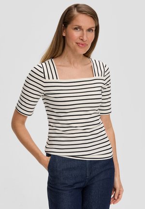 Gestreept t-shirt in crème en zwart, met een vierkante halslijn en korte mouwen. Zachte stof met een getailleerde pasvorm, gecombineerd met marineblauwe broek.