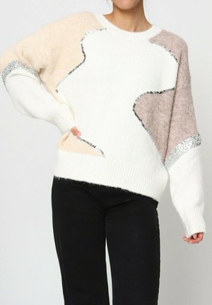 Pull en tricot avec une base blanche crémeuse ornée de formes abstraites beiges et marron clair, et des accents de sequins argentés sur les manches.