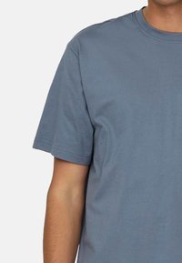 Blaues T-Shirt mit kurzen Ärmeln aus Baumwollmaterial, mit Rundhalsausschnitt, glatter Textur und ohne sichtbare Muster oder Akzente.