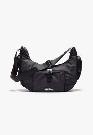 Borsa a spalla in nylon nero con una forma curvata, dotata di una tasca frontale con zip, tracolla regolabile e dettagli in hardware lucido.