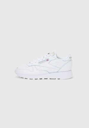 Weißer Reebok-Ledersneaker mit Schnürsenkeln, markantem seitlichem Logo und Gummisohle, im rechten Profil auf weißem Hintergrund gezeigt.