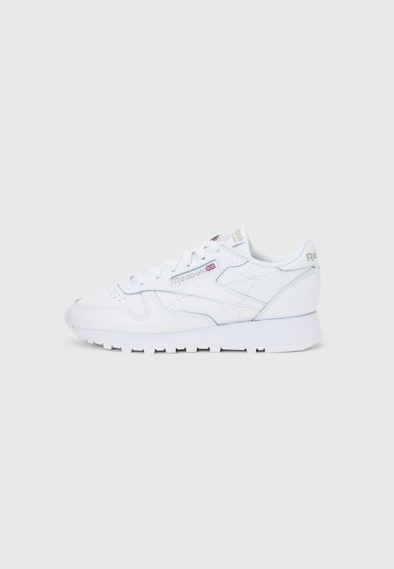 Pantof sport alb Reebok din piele, cu șireturi, logo de marcă pe lateral și talpă de cauciuc, prezentat în profil drept pe un fundal alb simplu.