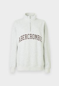 Jasnoszary sweatshirt z ćwierć zamkiem, z napisem "ABERCROMBIE" w ciemnych literach na piersi, z prążkowanymi mankietami i pasem.