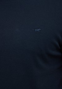 Granatowa sweterka z dzianiny z prążkowanym dekoltem, z haftowanym logo konia w nieco ciemniejszym odcieniu po lewej stronie.