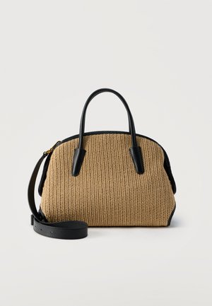 Πλεκτή τσαντά καφέ-ταμπά με μαύρες δερμάτινες λαβές, τρέσα και ρυθμιζόμενο ιμάντα ώμου, εκτεθειμένη σε απλό ανοιχτό φόντο.