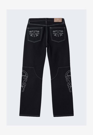 Jean noir avec des motifs blancs cousus sur les poches arrière et les jambes inférieures, dotés de jambes droites et d'une étiquette de marque en cuir sur la ceinture.