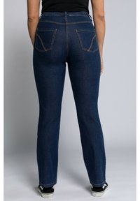 Jeans taille haute bleu nuit avec une coupe droite, dotés de deux poches arrière et de surpiqûres orange contrastantes le long des coutures.