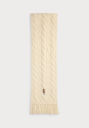 Knit cream scarf with cable pattern, fringed ends, and an embroidered logo featuring a bear character. Textured, soft wool material.