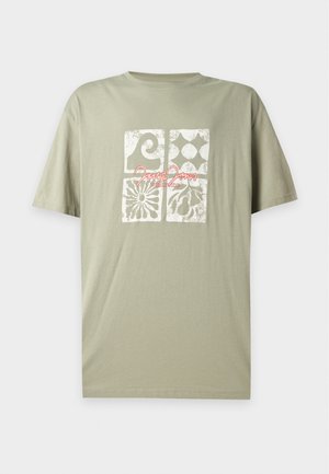 Φυστικί κοντομάνικο T-shirt με τέσσερα λευκά υφήριστα τετράγωνα σχέδια και κόκκινο κείμενο σε γραμματοσειρά "James Jeans Worldwide" στο μπροστινό μέρος.