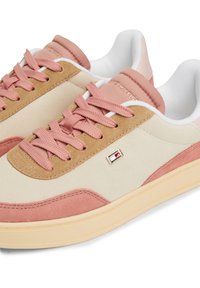 Light-colored sneakers featuring a mix of smooth and suede textures in beige, pink, and cream, with a logo accent on the side.