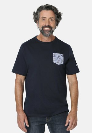 Camiseta de manga corta azul marino con cuello redondo y un bolsillo de un suave color azul claro con estampado. La tela parece suave y tiene un corte relajado.