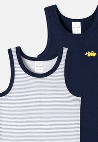 Due canottiere per bambini: una blu navy con un design di un trattore giallo, l'altra bianca con righe orizzontali blu navy. Entrambe hanno giros袖 coordinati.
