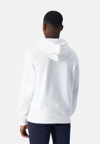 Witte hoodie gemaakt van zachte stof, met een capuchon met trekkoord, lange mouwen en een relaxte pasvorm. Glad textuur, minimalistisch ontwerp.
