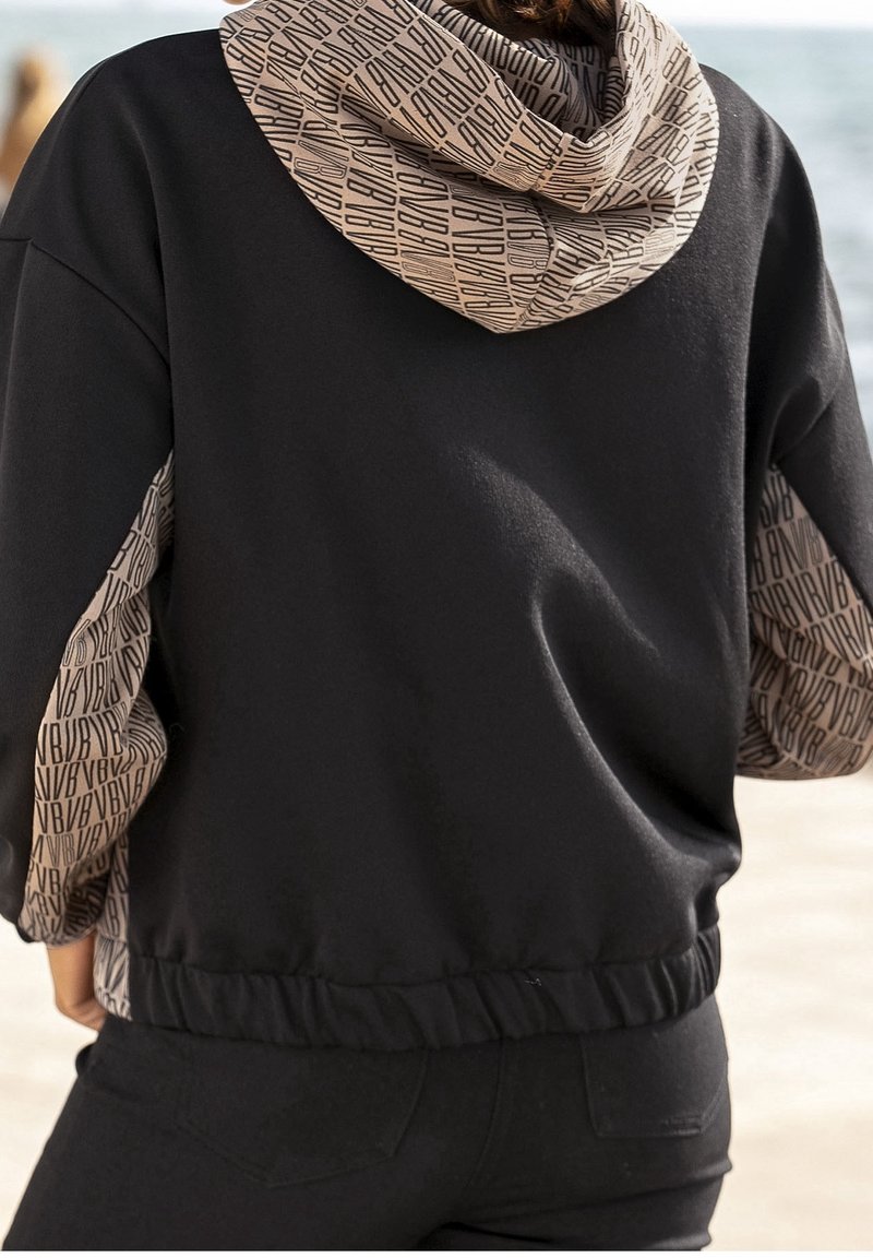 Felpa nera con cappuccio e maniche a motivo beige. Presenta orlo e polsini elasticizzati, texture morbida e elementi di design a contrasto.