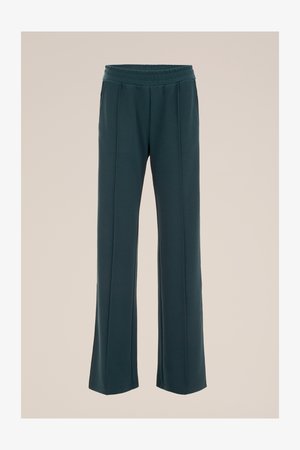 T tumedad teal, laiad püksid venitatava vööga ja peente volditega. Valmistatud siledast kangast pehme tekstuuriga.