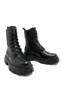 Botas negras de cuero hasta el tobillo con un acabado texturizado, cordones en la parte delantera y cremallera lateral, que presentan una suela gruesa y una silueta robusta.