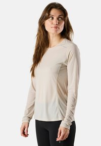 Lange mouwen sportshirt in lichtbeige, gemaakt van ademend stof met een subtiele textuur, voorzien van een ronde hals en aansluitende mouwen.