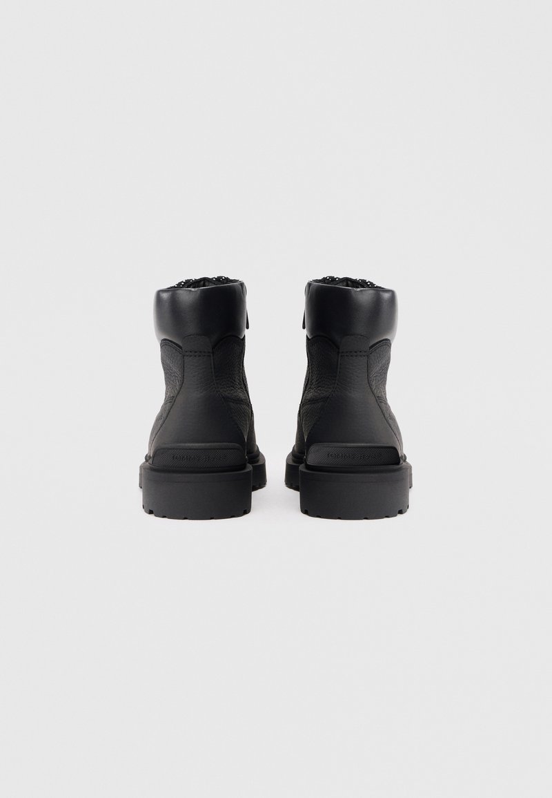 Black ankle boots with textured leather and smooth accents. Features a rugged sole and cushioned collar for support.