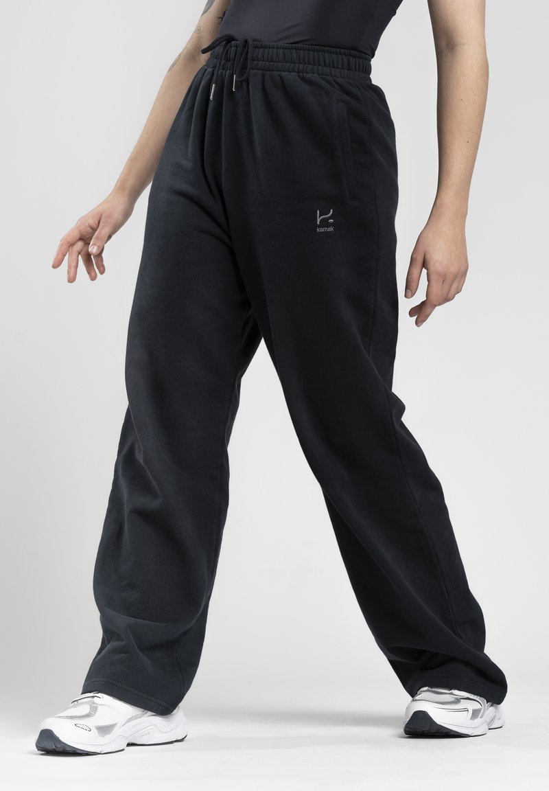 Schwarze, locker sitzende Sweatpants mit elastischem Taillenbund und Kordelzug. Mit Seitentaschen und einem kleinen Logo auf der Vorderseite.