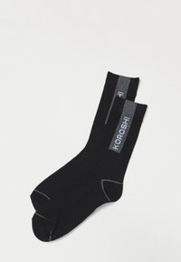 Calcetines negros con una textura suave, que presentan un logo gris y rayas en el puño. Tienen una forma y un acabado clásicos.