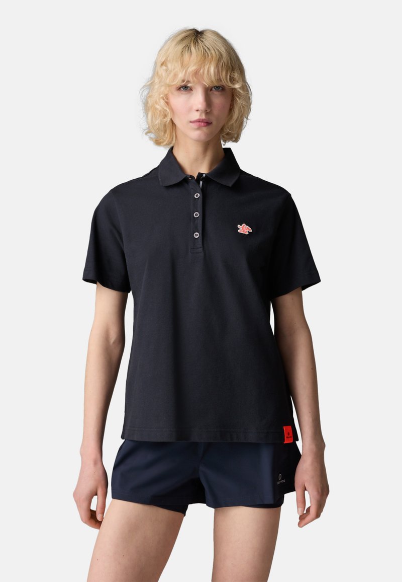 Schwarzes Polohemd mit Kragen, kurzen Ärmeln und einem roten Logopatch auf der Brust. Hergestellt aus glattem Stoff mit einer lockeren Passform.