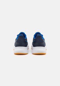 Dark blue athletic shoes with a textured mesh upper, blue accents, white midsole, and orange rubber outsole, viewed from the rear.
