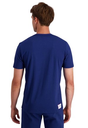 Camiseta de algodón azul marino con cuello redondo, mangas cortas y una etiqueta tejida en el lateral inferior con un diseño divertido.