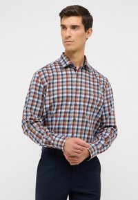 Camicia a quadri multicolore con quadrati blu, marroni e beige, maniche lunghe, chiusura con bottoni e colletto classico. Tessuto dalla texture liscia.