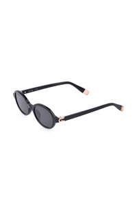 Lunettes de soleil noires à monture ronde avec verres foncés et branches fines avec des accents en or rose sur les charnières et les extrémités.