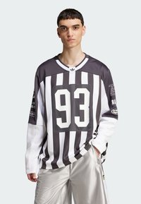 Mustvalge triibuline piksevarrukatega jersy, mille esiküljel on suur number "93", võrgumuster, koos hõbedaste spordilühikestega.