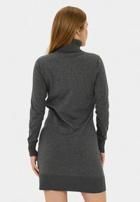 Abito grigio a collo alto lavorato a maglia con maniche lunghe, polsini e orlo a coste. Tessuto morbido e silhouette aderente che si estende fino a metà coscia.