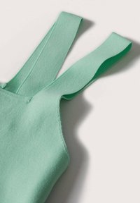 Haut vert menthe avec des bretelles larges et douces et une texture lisse. Présente un design ajusté avec des coutures soignées le long des bords.