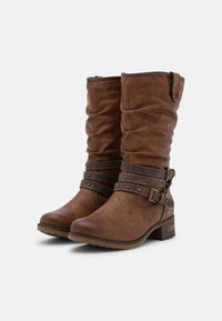 Bottes mi-mollet en simili cuir marron avec une texture plissée, deux sangles ajustables avec des clous et un petit talon épais.