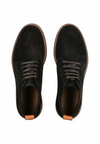 Scarpe in suede nere con lacci, punta rotonda, dettagli in pelle marrone sul tallone e suola in gomma con cuciture decorative.