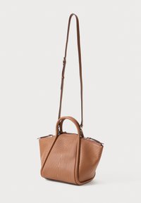 Brown leather handbag with a textured, wavy design, dual handles, and an adjustable shoulder strap. Features silver zippers.