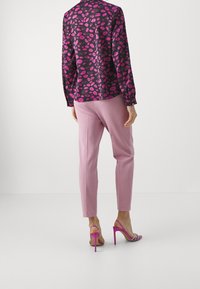 Purple blouse with a leaf pattern, paired with light pink tailored pants and pink high-heeled sandals. Back view displayed.